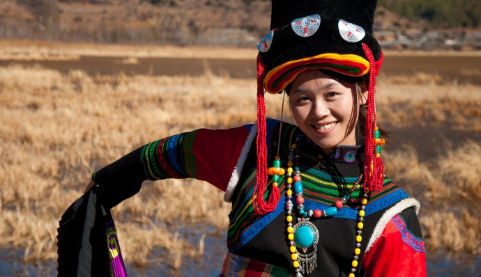 Una turista sonríe ataviada con un traje típico 'mosuo'. MIKEL BUTRAGUEÑO